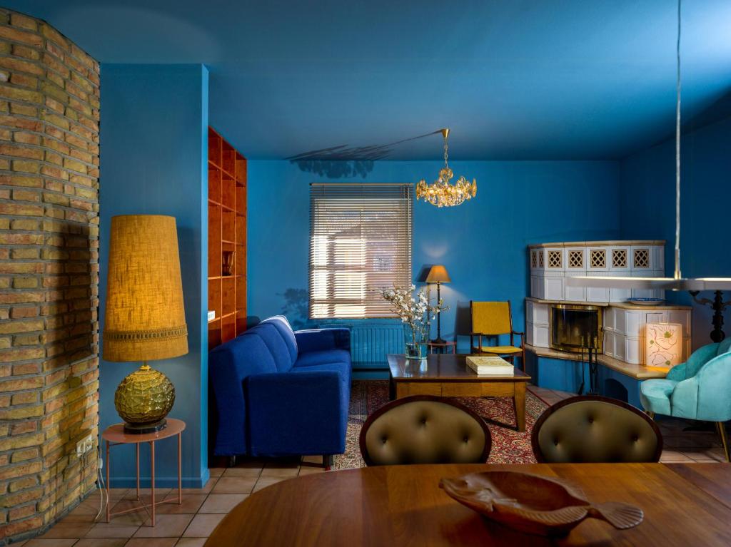 a blue living room with a couch and a table at Stylish Apartment Zander On The Eider River Bend in Süderstapel