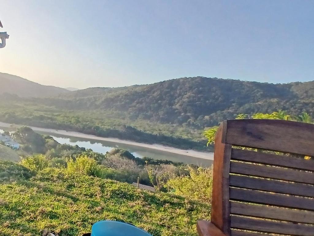 Riverview Cottage : كرسي خشبي يجلس على تلة تطل على النهر