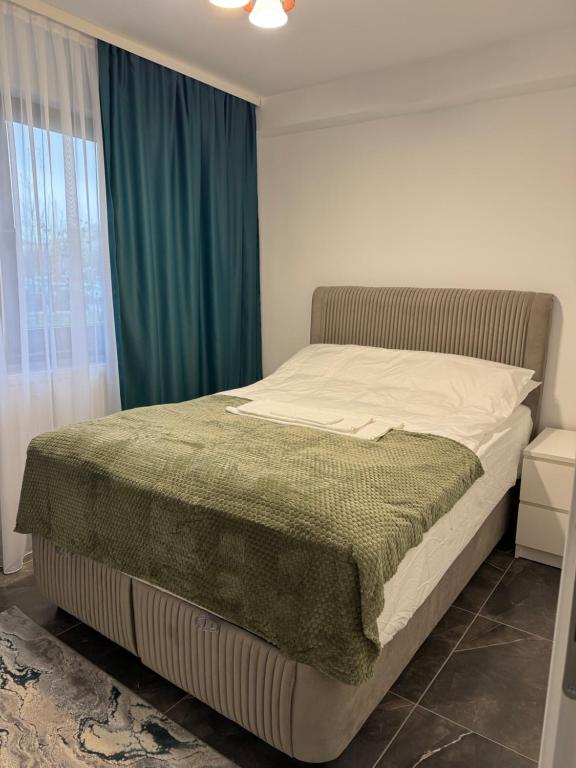 une chambre avec un lit avec une couverture verte dessus dans l'établissement Albert Studio, à Drobeta-Turnu Severin