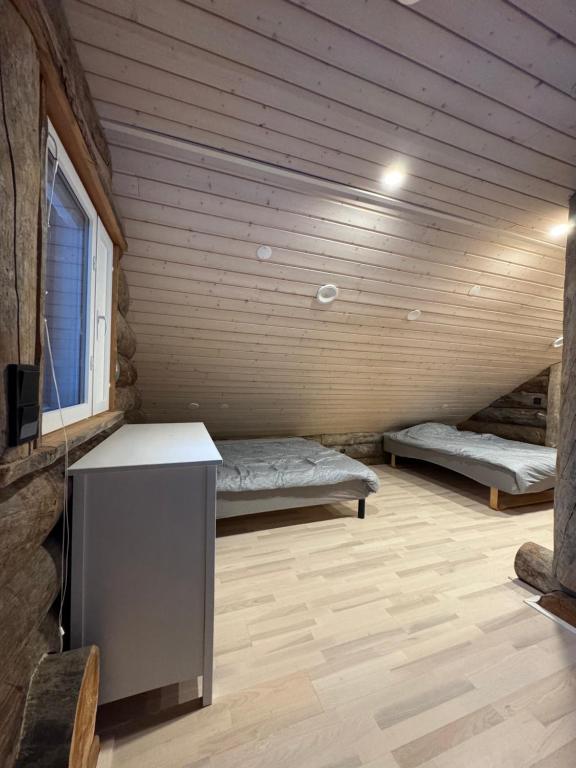 a room with two beds and a desk in a cabin at Aurora Forest Lodge Ylläs in Äkäslompolo