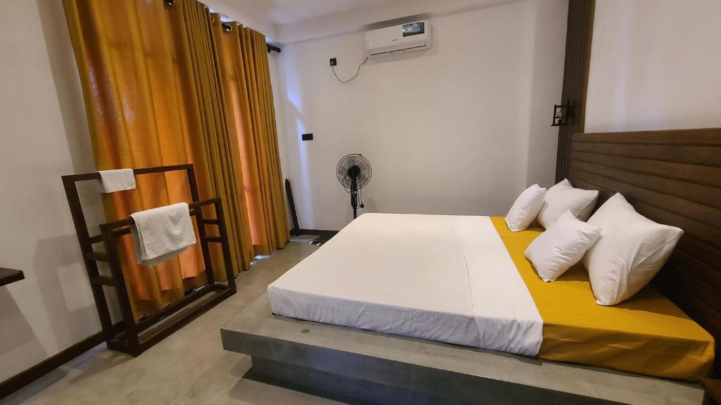 a bedroom with a bed with white sheets and pillows at Ametz Politak in Weligama