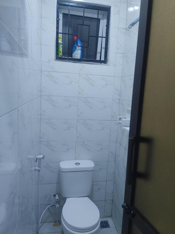Un baño blanco con inodoro y ventana. en Kwa Engineer, en Wajir