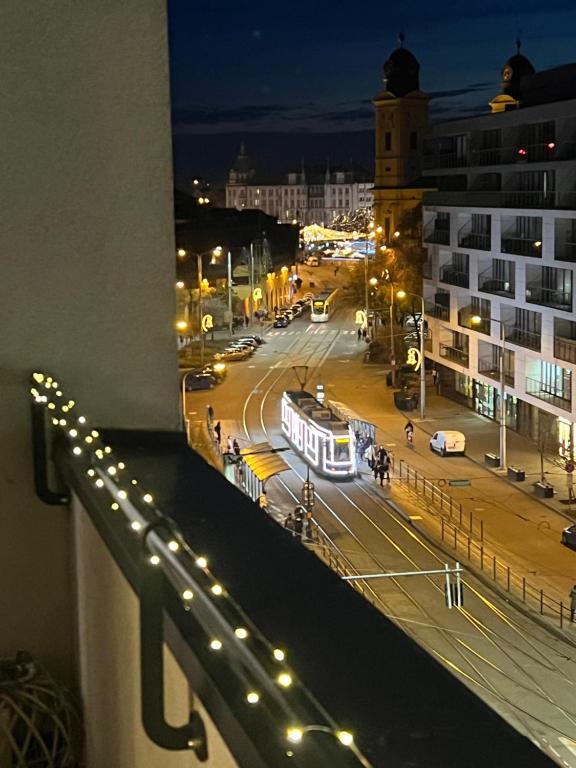 a view of a city street at night with a bus at Paris Yard Apartman with free parking in Debrecen