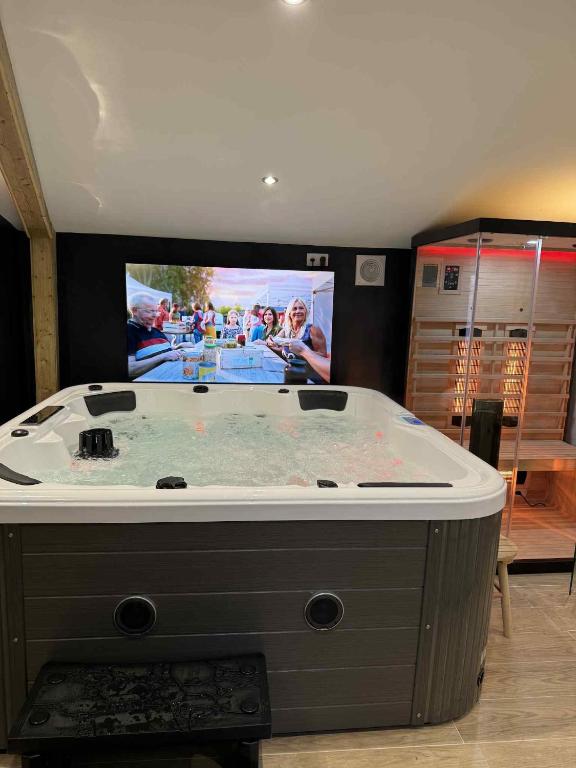 a large bath tub in a room with a tv at Spa Sola in Mecquignies