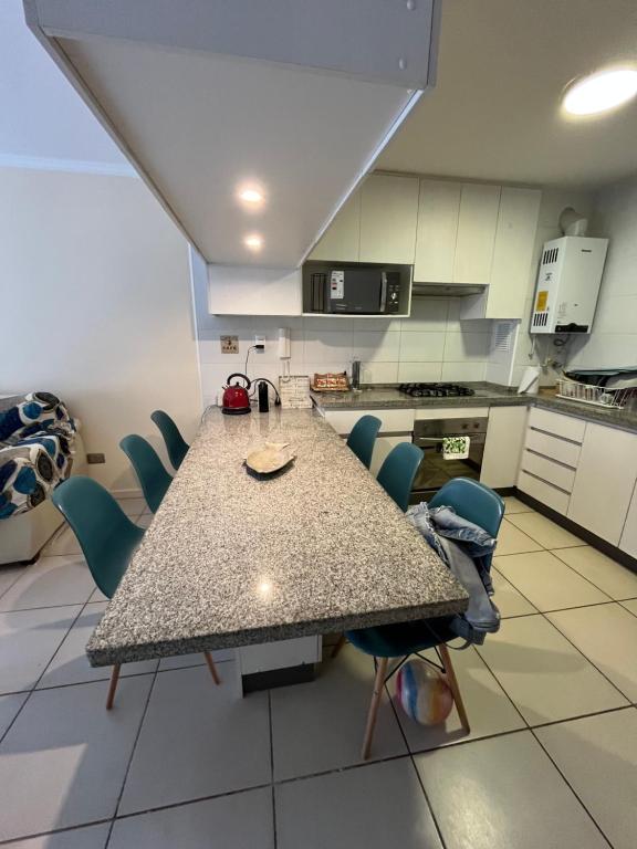 Cómodo Depto en bosques de la candelaria في ألغاروبو: مطبخ مع طاولة وكراسي في الغرفة