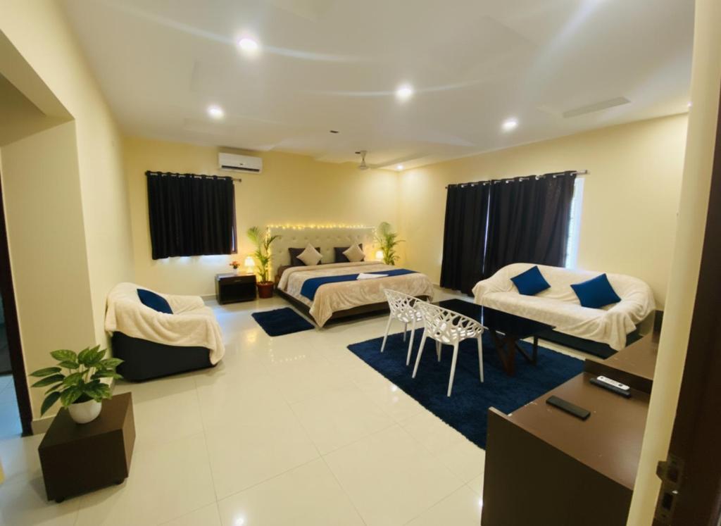 a bedroom with two beds and a living room at Hotel Velvet Stay Near DLF Cyber City in Hyderabad