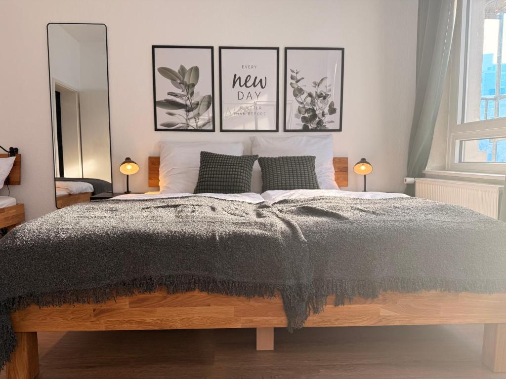 a bedroom with a bed with four pictures on the wall at StaySimplyHaven - Modernes City-Apartment, King-Size Bett, 55'' Smart-TV, Self Check-In in Braunschweig
