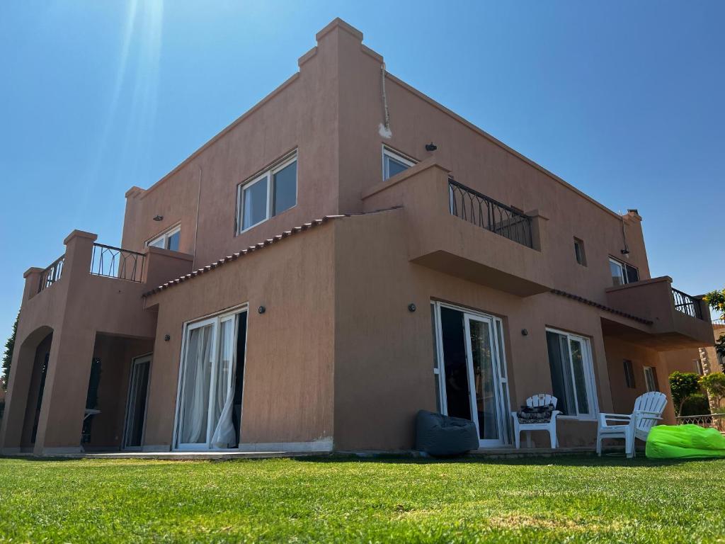 a brown house with a green lawn in front of it at Private Villa Sea View 5BR in Ain Sokhna