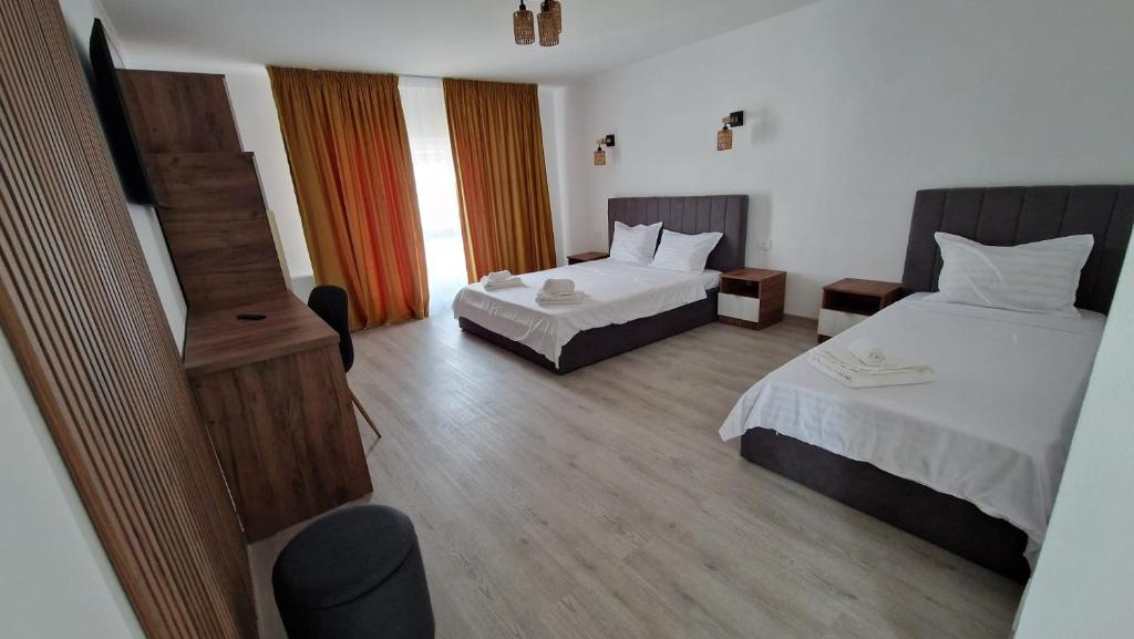 En eller flere senge i et værelse på Pensiunea Ramedal