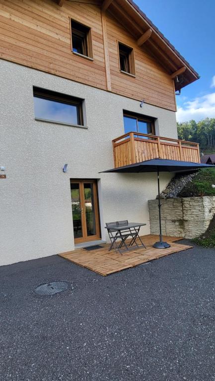 Una casa con una mesa de picnic delante de ella. en La Longeret du Bouchet Mont Charvin, en Le Bouchet-Mont Charvin