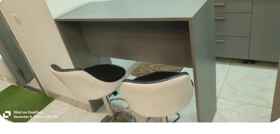 a desk with two white chairs under it at Stodio apartment Noida greater Noida in Ghaziabad