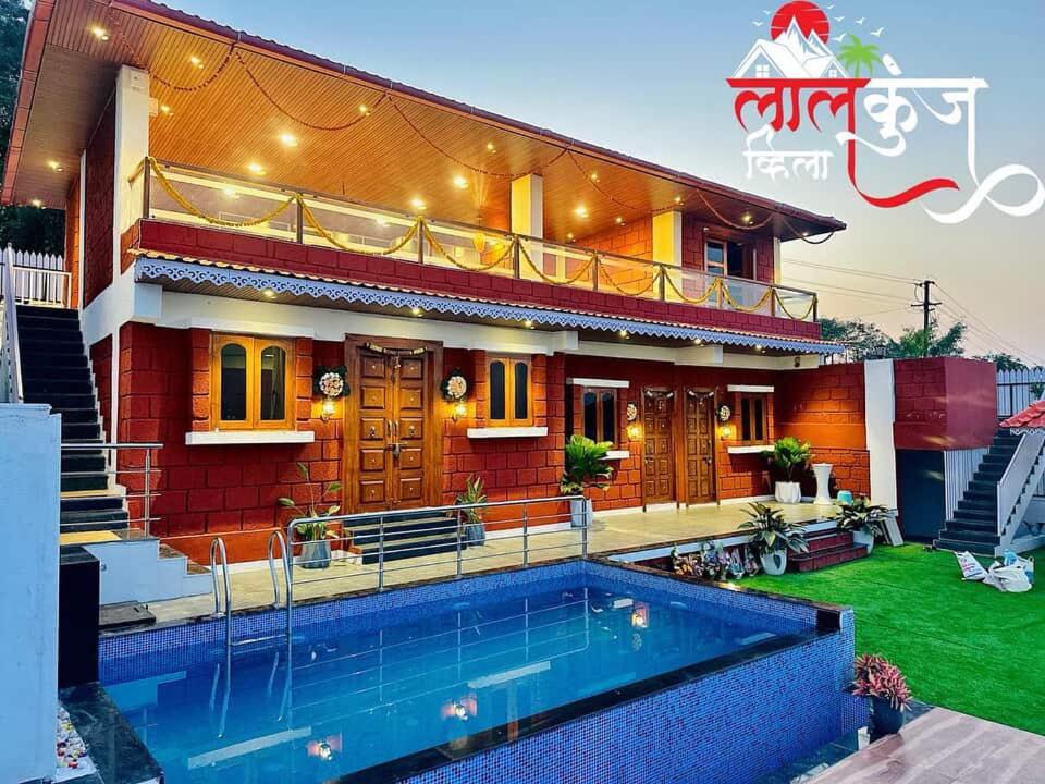 a house with a swimming pool in front of it at Laalkunj villa in Pune