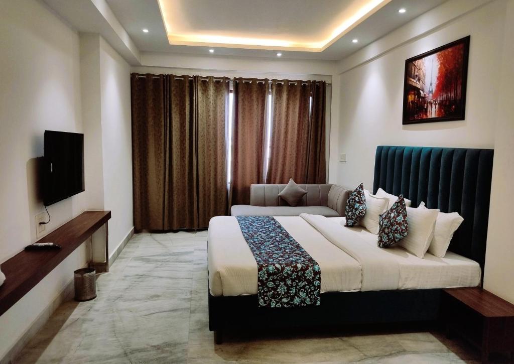 a hotel room with a bed and a television at Ritz The Boutique Hotel in Rohtak