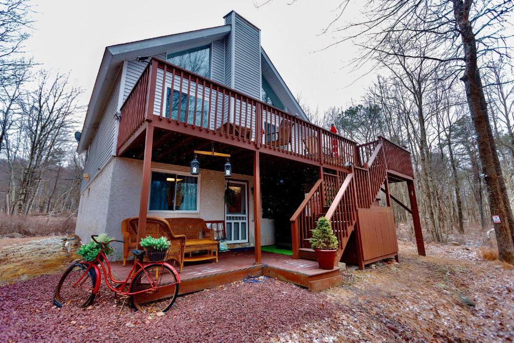 una casa con terraza y una bicicleta delante de ella en Poconos Getaway with Hot Tub-Close to Attractions, Perfect for Family &Friends!, en Blakeslee