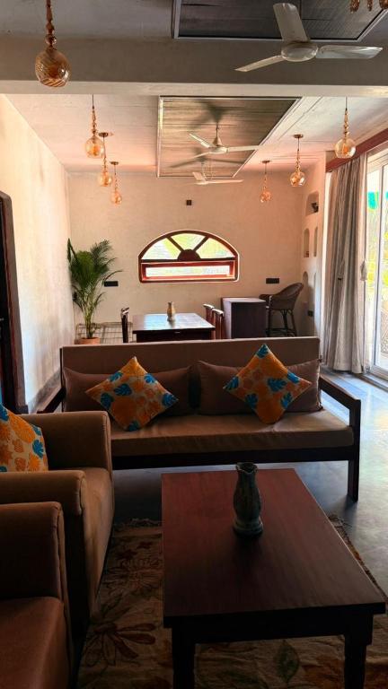 a living room with a couch and a table at Chique Shanti Villa in Mandrem