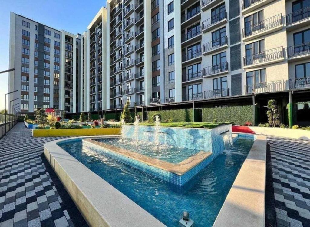 una fontana in un cortile di fronte a un edificio di Prestige Apartament a Tashkent