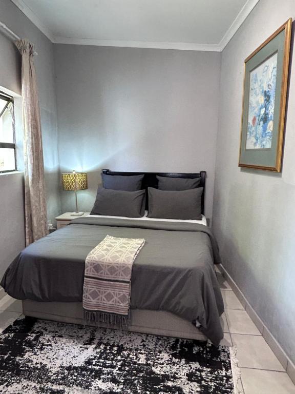 a bedroom with a large bed in a room at Cozy pool side cottage in Roodepoort