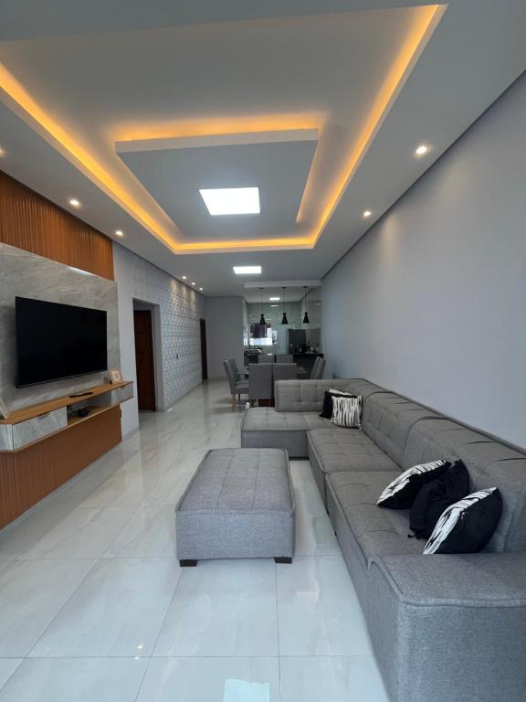 een woonkamer met banken en een flatscreen-tv bij Impera House Casa com piscina in Imperatriz