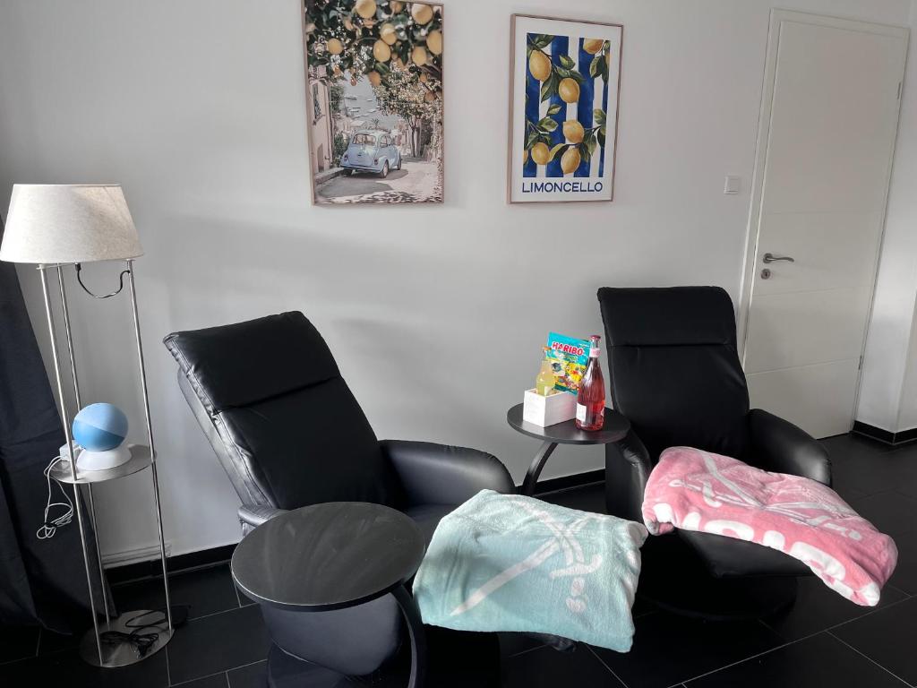 a living room with two chairs and a lamp at Weserbergland Lodge im Wiesenweg in Holzminden in Holzminden