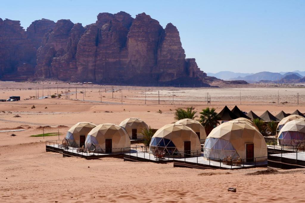 a row of tents in a desert with a mountain at Hasan Zawaideh Camp in Wadi Rum