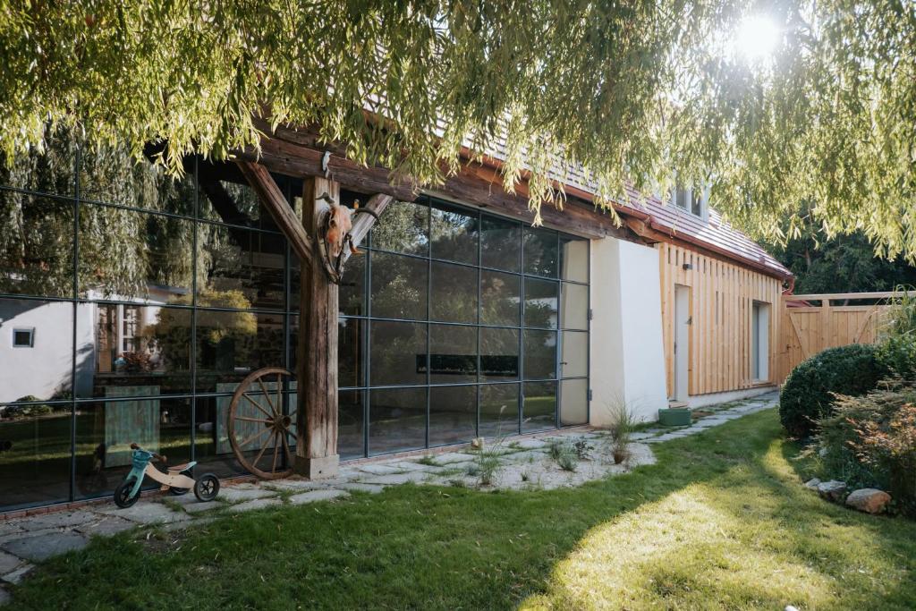 a house with a large window and a bike in the yard at Usedlost Ledňáček - Boutique Wellness & SPA in Písečné