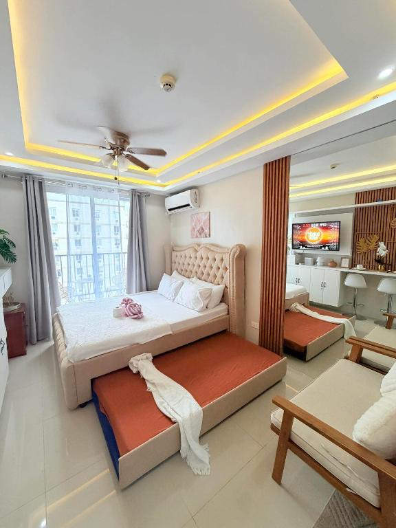 a bedroom with a large bed and a living room at saekyung marigondon 1 in Lapu Lapu City