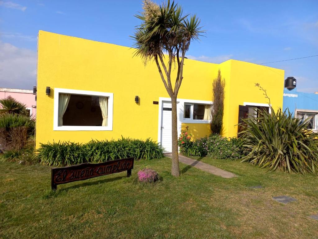 een geel huis met een bord ervoor bij Casa en Mar de Cobo in Mar de Cobo