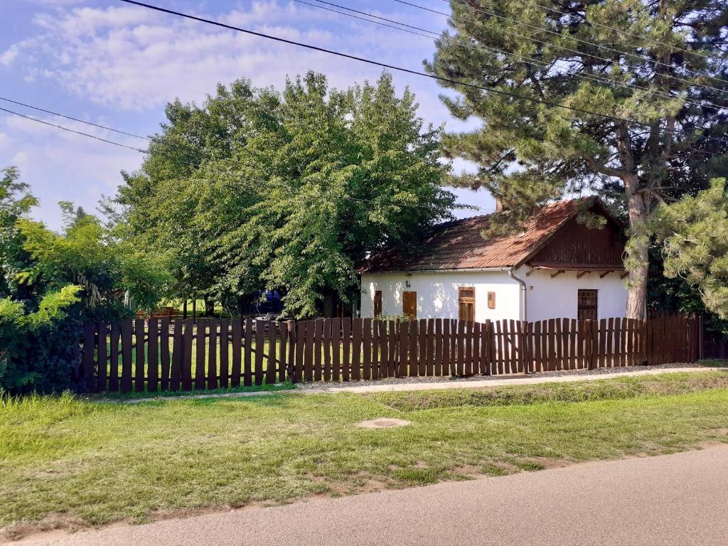 a small white house behind a wooden fence at Rustic Harmony in Abádszalók