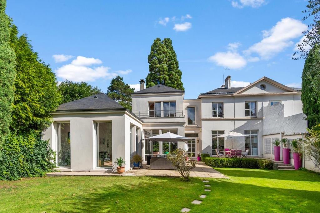 a large white house with a yard at Villa Séquoia Saint-Germain-en-Laye in Saint-Germain-en-Laye