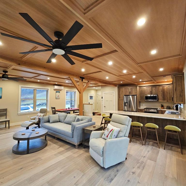 Powder Run - Modern 3BR Basecamp with Hot Tub, AC, EV Charger & Flat Parking في North Sherburne: غرفة معيشة مع كنب ومروحة سقف