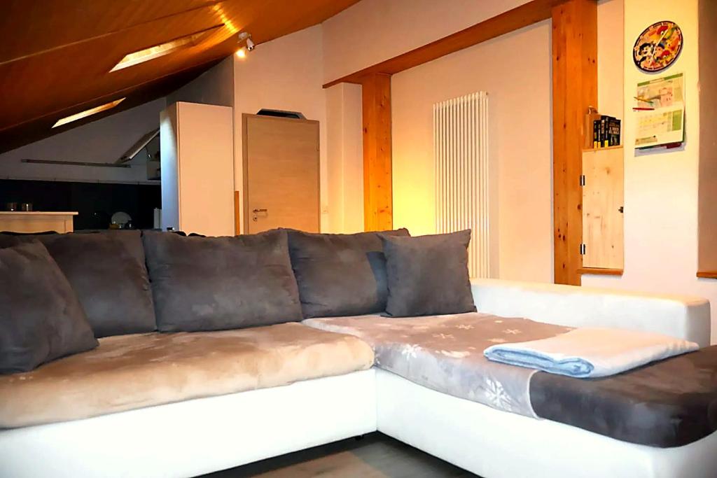 Ampio appartamento con travi a vista - Riviera في Osogna: أريكة جلدية كبيرة في غرفة المعيشة