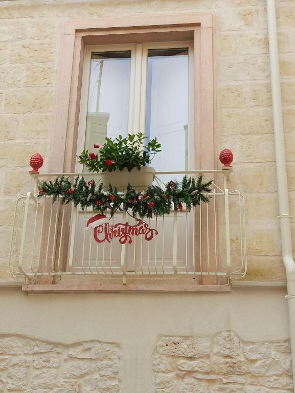Zia Giacomina's House في كاسانو ديلي مورجي: شرفة بها نباتات وزينة عيد الميلاد