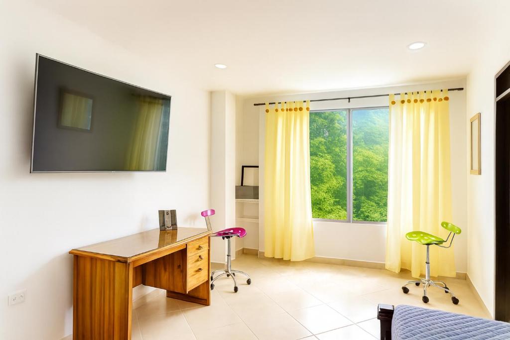 Cerete con Estilo في Cereté: مكتب منزل مع مكتب ونافذة كبيرة