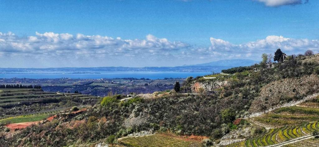 a view of the water from a hill with a valley at La casa di Lilly in SantʼAmbrogio di Valpolicella