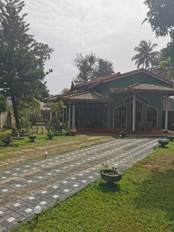 a house with a walkway in front of a building at Green Relax Villa in Mirissa