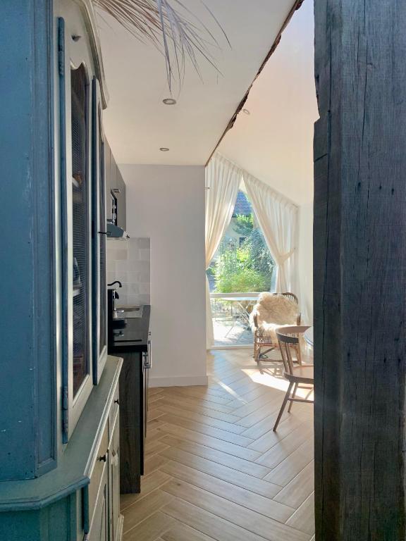 a kitchen with white walls and a wooden floor at La Bastide in Heiloo