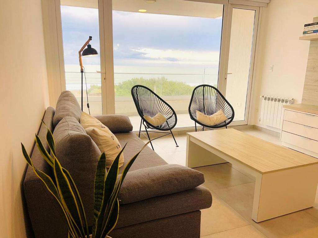 a living room with a couch and two chairs at Carpe Diem Monte Hermoso in Monte Hermoso