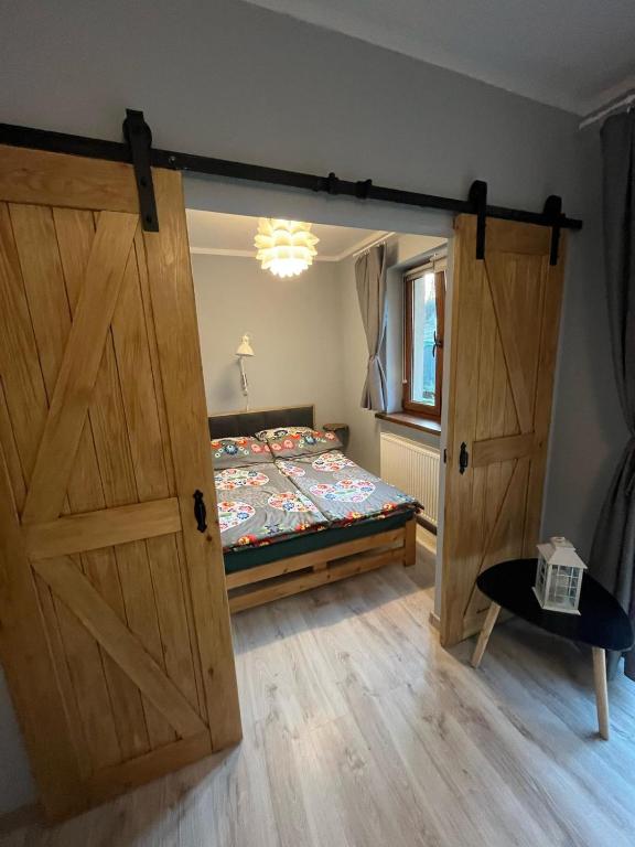 a bedroom with a bed and a large wooden door at Beskidzka 25a in Szczyrk