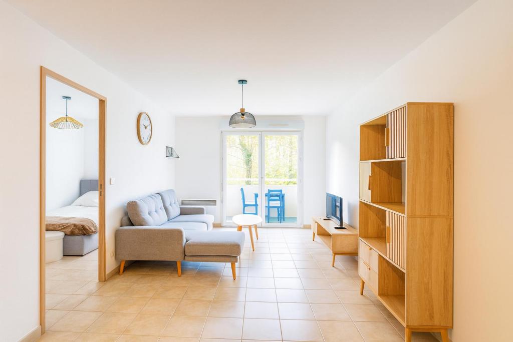 ein Wohnzimmer mit Sofa und Tisch in der Unterkunft Appartement avec balcon parking Alès centre in Alès