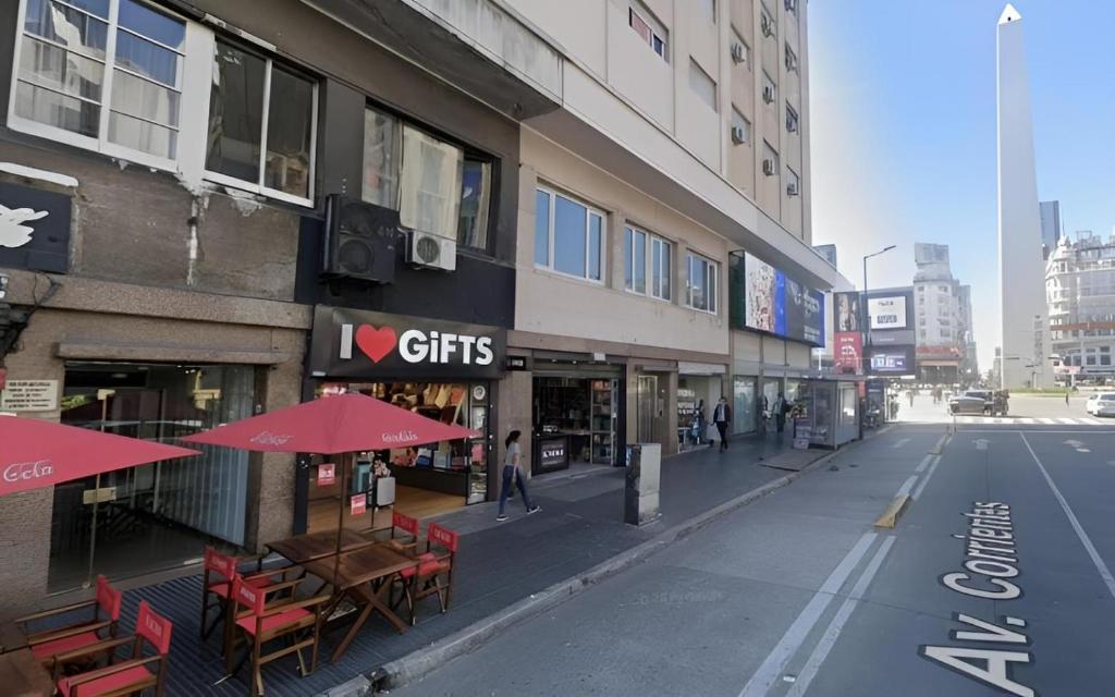 Hermoso departamento con vista a Obelisco lV في بوينس آيرس: شارع فارغ في مدينة به طاولات ومظلات