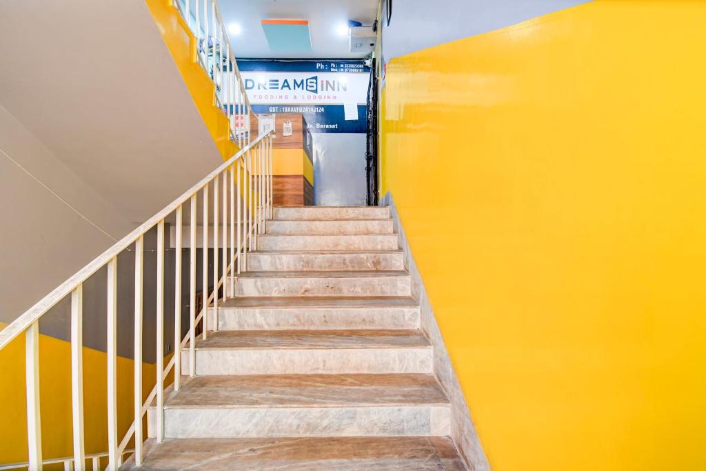 a staircase in a building with yellow walls at Hotel O Elixir in Dohāri