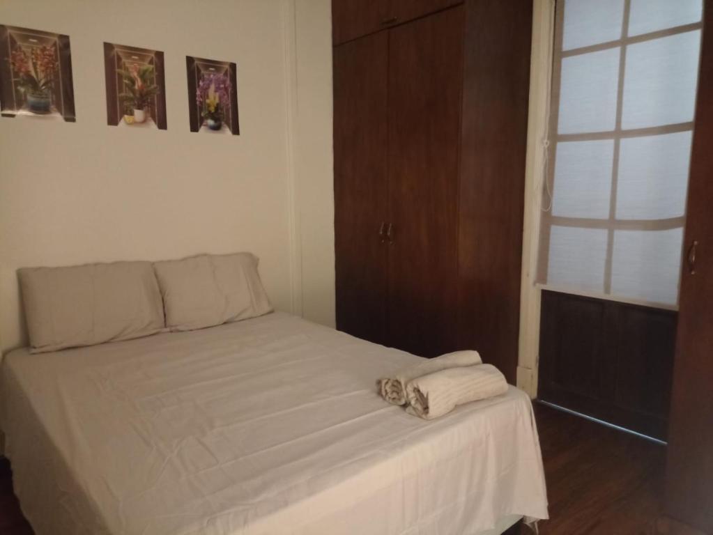 モンテビデオにあるRoom in shared flat, Art Deco apartament in center cityのベッドとタオル2枚のある寝室