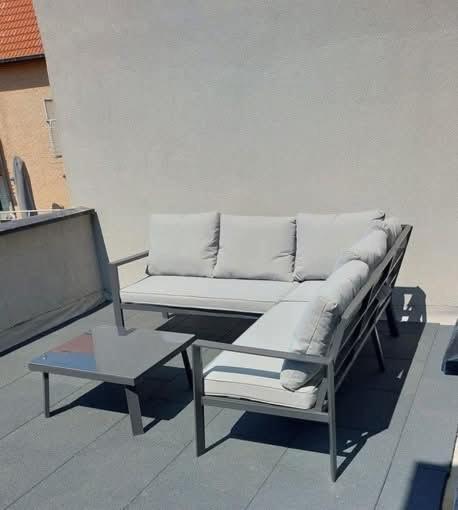 a couch and a coffee table on a balcony at Jagersrust aan zee in Blankenberge