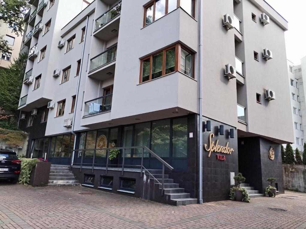 a large white building with a staircase in front of it at Apartman Besu in Vrnjačka Banja