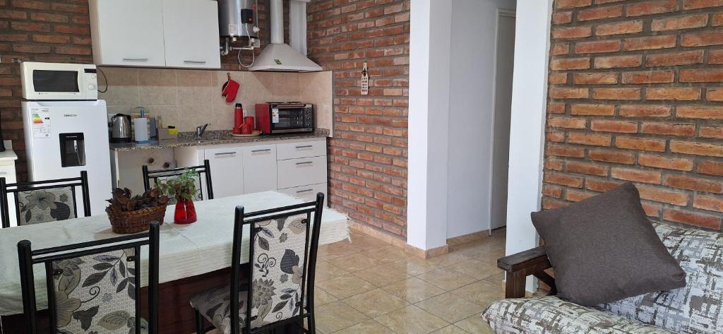 a kitchen with a table and a brick wall at Nuevo Complejo Milena in San Juan