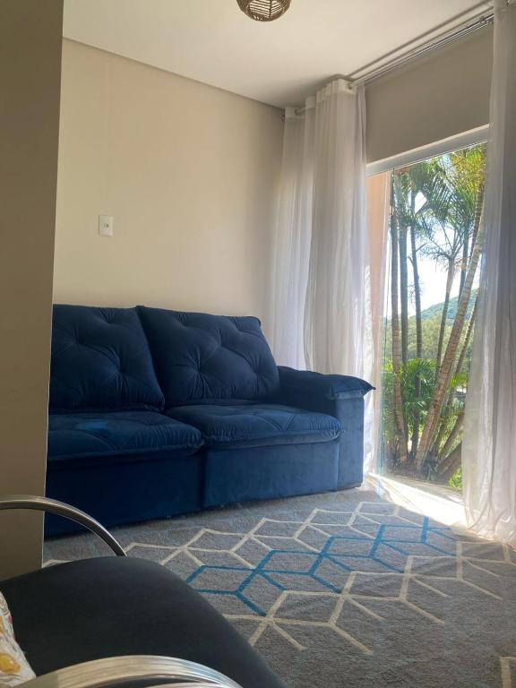 a blue couch in a living room with a window at Casa Star - Vista para as Montanhas in Monte Sião