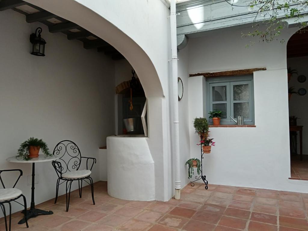 a patio with a table and chairs and a window at Casa del Sacramento - CASITA CON ENCANTO in Medina Sidonia