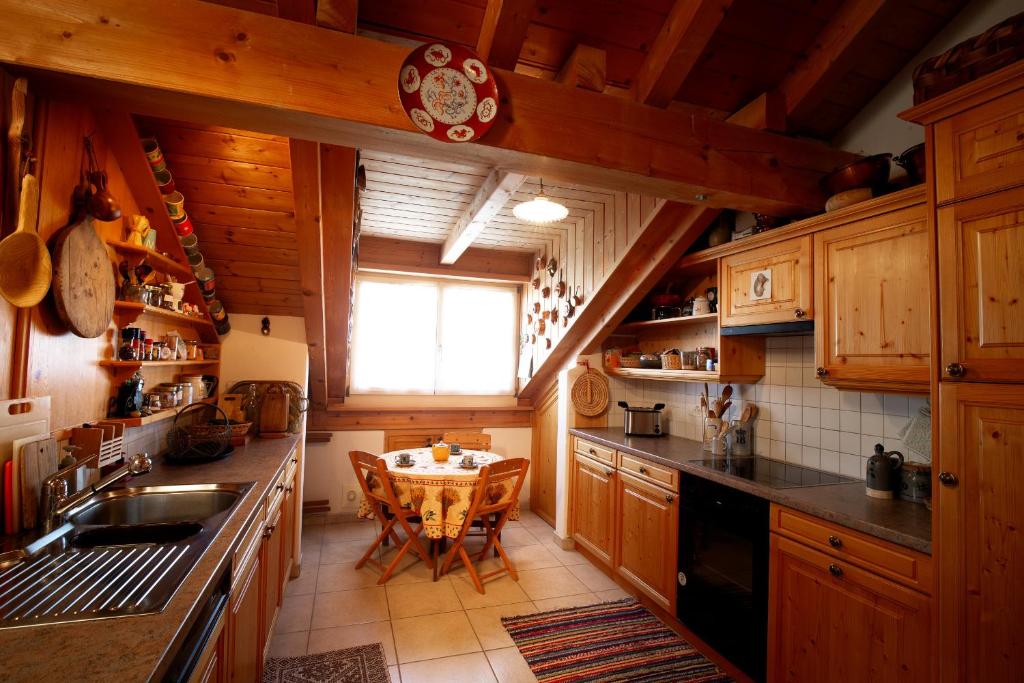 Una cocina con gabinetes de madera y una mesa en ella. en Chesa Principela - La Punt, en La Punt-Chamues-ch