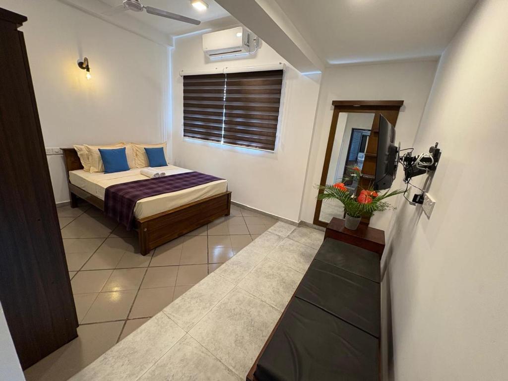 Un dormitorio con una cama y un televisor. en Villa DEE DEE & Wellness, en Galle