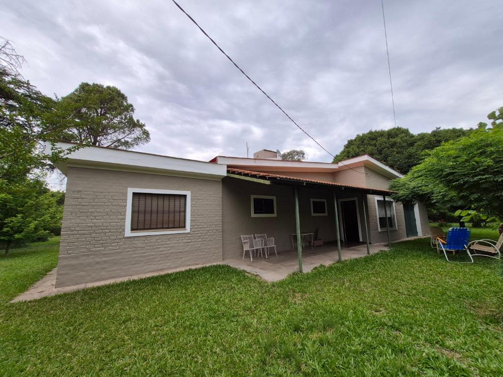 a small house with chairs in the yard at Oasis in Villa Anizacate